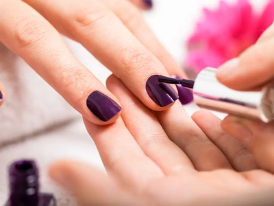 Esmaltando uñas de color violeta