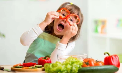 Una nena jugando con comida y riendo